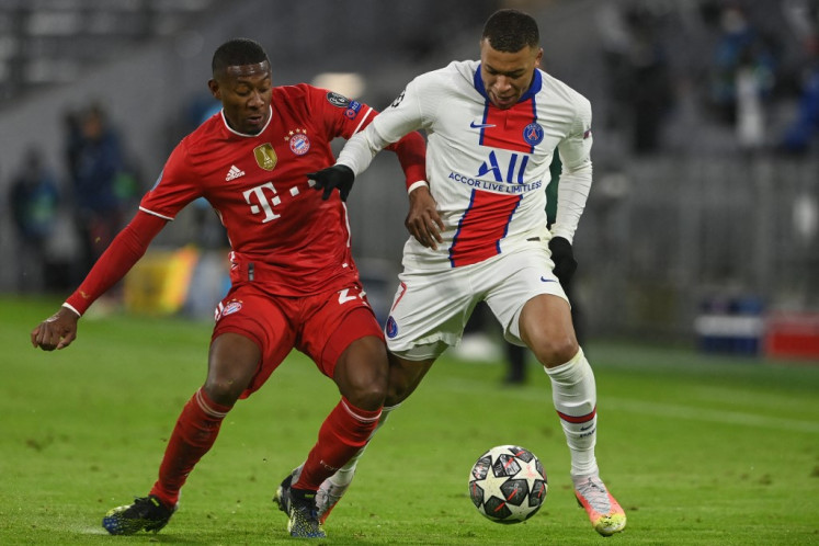 Bayern Munich's Austrian defender David Alaba (L) and Paris Saint-Germain's French forward Kylian Mbappe vie for the ball during the UEFA Champions League quarter-final first leg football match between FC Bayern Munich and Paris Saint-Germain (PSG) in Munich, southern Germany, on April 7, 2021.