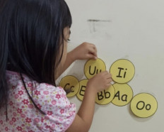 Gita does an assignment at home for an online class.