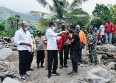 This handout photo taken and released on April 9, 2021 by the Indonesian Presidential Palace shows President Joko Widodo (C) giving his jacket to a survivor while inspecting damage on Lembata Island after torrential rains from Tropical Cyclone Seroja - one of the most destructive storms to hit the region in years - killed more than 200 people, including victims in neighbouring East Timor, with dozens still missing.