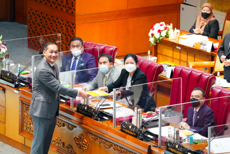 Trade Minister Muhammad Lutfi hands over a document to House Speaker Puan Maharani after legislators approved a draft bill of the trade deal in Jakarta on Friday, April 9, 2021.