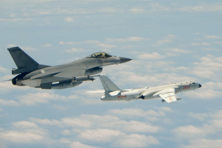 This handout photograph taken and released on May 11, 2018 by Taiwan's Defence Ministry shows a Republic of China (Taiwan) Air Force F-16 fighter aircraft (left) flying alongside a Chinese People's Liberation Army Air Force (PLAAF) H-6K bomber that reportedly flew over the Bashi Channel, south of Taiwan, and over the Miyako Strait, near Japan's Okinawa Island, in a drill. China sent fighter jets and other military aircraft near Taiwan on May 11 in the latest of a series of drills which Beijing has said are aimed at the island's 