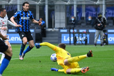 Inter Milan's Italian defender Matteo Darmian (Rear L) prepares to shoot and score the opening goal past Cagliari's Italian goalkeeper Guglielmo Vicario (Bottom) during the Italian Serie A football match Inter Milan vs Cagliari on April 11, 2021 at the San Siro stadium in Milan.
