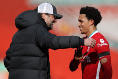 Liverpool's German manager Jurgen Klopp (L) congratulates Liverpool's English defender Trent Alexander-Arnold after the English Premier League football match between Liverpool and Aston Villa at Anfield in Liverpool, north west England on April 10, 2021. Liverpool won the match 2-0.