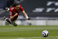 Manchester United's Uruguayan striker Edinson Cavani heads the ball and scores during the English Premier League football match between Tottenham Hotspur and Manchester United at Tottenham Hotspur Stadium in London, on April 11, 2021.