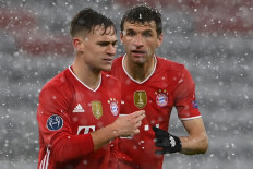 Bayern Munich's German forward Thomas Mueller (R) has words with Bayern Munich's German midfielder Joshua Kimmich during the UEFA Champions League quarter-final first leg football match between FC Bayern Munich and Paris Saint-Germain (PSG) in Munich, southern Germany, on April 7, 2021.