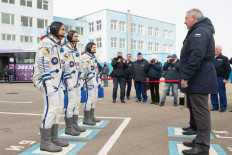 This Russia's space agency Roscosmos handout picture taken and released on April 9, 2020 shows NASA astronaut Chris Cassidy and Russian cosmonauts Anatoly Ivanishin and Ivan Vagner, members of the International Space Station (ISS) expedition 63, report to Roscosmos chief Dmitry Rogozin as they walk to board the Soyuz MS-16 spacecraft prior to the launch at the Russian-leased Baikonur cosmodrome in Kazakhstan. 