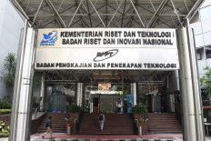 Employees walk into the Research and Technology Ministry's building in Jakarta on April 11.
