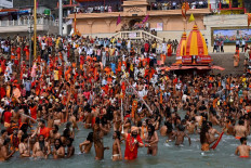 Naga Sadhus (Hindu holy men) take a holy dip in the waters of the Ganges River on the day of Shahi Snan (royal bath) during the ongoing religious Kumbh Mela festival, in Haridwar on April 12, 2021. 