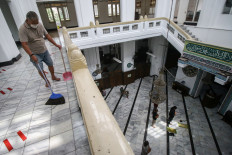 A mosque worker cleans the praying area of the Cut Meutia Mosque in Central Jakarta on April 10. The Jakarta administration allows Muslims to perform congregational tarawih (Ramadan evening prayers) at mosques under strict health protocol.
