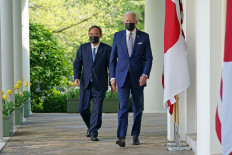 US President Joe Biden and Japan's Prime Minister Yoshihide Suga walk through the Colonnade to take part in a joint press conference in the Rose Garden of the White House in Washington, DC on April 16, 2021. 