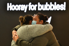 A woman hugs a family member before his departure for New Zealand at Sydney International Airport on April 19, 2021, as Australia and New Zealand opened a trans-Tasman quarantine-free travel bubble. 