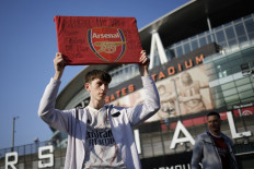 An Arsenal fan stands an anti-European Super League banner outside the Emirates Stadium, home of English Premier League football club Arsenal, in north London on April 19, 2021. Twelve of Europe's biggest clubs on Monday said they planned to launch a breakaway Super League, despite the threat of an international ban for them and their players. 