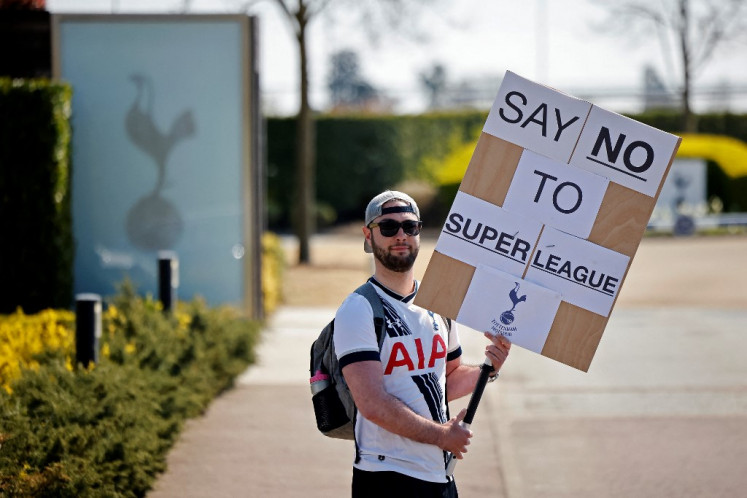A Tottenham Hotspur's fan holds an anti-European Super League placard has he demonstrates outside the English Premier League football club's training ground in north London on April 19, 2021. Arsenal and Tottenham Hotspur fans enjoy a fierce rivalry but the announcement of the European Super League achieved the rare feat of uniting them virtually as one in condemning it.