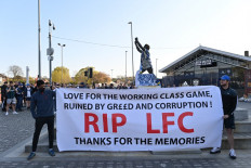 Leeds United fans hold a banner against plans for a European Super League and the involvement of Liverpool football club outside Elland Road ahead of the English Premier League football match between Leeds United and Liverpool in Leeds, northern England, on April 19, 2021. Twelve of Europe's biggest clubs on Monday said they planned to launch a breakaway Super League, despite the threat of an international ban for them and their players. 