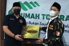 Chairman of AM64, a group of Canisius College Catholic high school alumni in Menteng, Central Jakarta, Irlan Suud, hands over a gift to deputy chairman of GP Ansor's Jakarta chapter, Sulton Mu'minah, during a visit on March 20. 