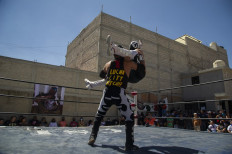 Mexican wrestlers take part in the clandestine backyard show Hall of Fame, mounted by extreme wrestling organizer Zona 23, which pays tribute to wrestler Israel Montiel Leon, "Ovett", who died of COVID-19 in February this year at the age of 44, and two other fighters, in Cuautitlan Izcalli, Mexico State, Mexico, on April 4, 2021. Almost 200 Mexican extreme wrestlers have died from COVID-19, their worst contender.