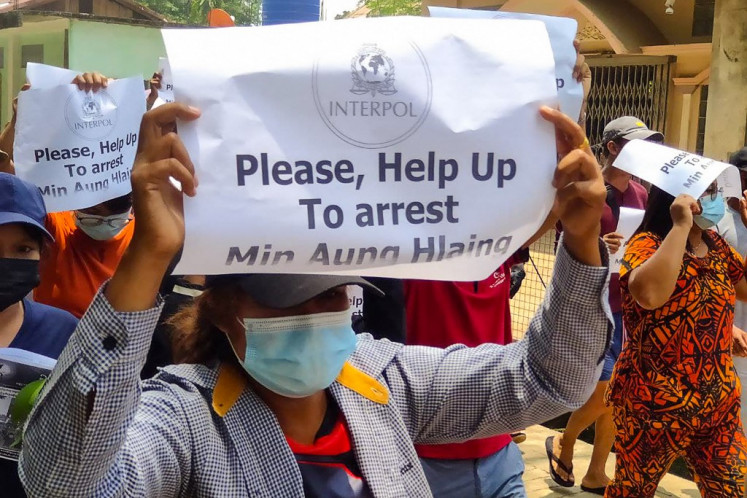 This handout photo taken and released by Dawei Watch on April 23, 2021 shows protesters holding signs calling for the arrest of Myanmar armed forces chief Senior General Min Aung Hlaing during a demonstration against the military coup in Dawei. 
