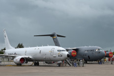 Visitors stand next to a static display of the US Navy aircraft the Poseidon P-8 (left) and the USAF Boeing C-17A Globemaster III (right) on the tarmac during the Singapore Airshow in Singapore on February 11, 2020. 