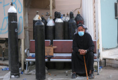 An Iraqi man waits next to oxygen bottles for his wife who is a patient with COVID-19 at the Ibn Al-Khatib Hospital in Baghdad, on April 25, 2021, after a fire erupted in the medical facility reserved for the most severe coronavirus cases. At least 23 people died when a fire broke out in a coronavirus intensive care unit in the capital of Iraq, a country with long-dilapidated health infrastructure facing mounting COVID-19 cases.