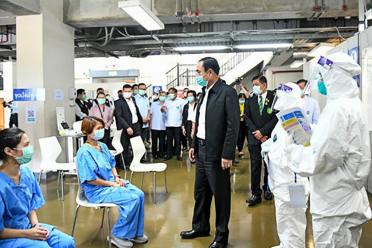 This handout from the Bangkok Metropolitan Administration taken and released on April 21, 2021 shows Thailand's Prime Minister Prayut Chan-O-Cha (center) visiting a field hospital set up in the Bangkok Arena indoor multi-purpose sporting venue to accomodate an upsurge in the number of Covid-19 coronavirus cases in the country. 
