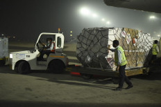 In this handout photograph taken taken on April 27, 2021 and released by the Foreign, Commonwealth and Development Office shows ground staff unloading medical aid from an aircart sent from the United Kingdom upon its arrival at an airport, in New Delhi. 