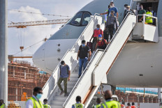 Passengers disembark from a Qatar Airways aircraft upon their arrival at the Velana International Airport in Male on July 15, 2020. The Maldives formally reopened for tourists on July 15 with a water salute for a commercial airliner bringing holiday makers to the upmarket destination where foreigners will get free coronavirus tests.