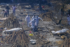 Family members and relatives perform the last rites amid the funeral pyres of victims who died of the Covid-19 coronavirus during mass cremation held at a crematorium in New Delhi on April 27, 2021. 