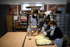 Volunteers of the 'Une chorba pour tous' (A soup for everyone) NGO prepare meals to be distributed to people in need on the first day of the holy month of Ramadan in Paris on April 13, 2021. 