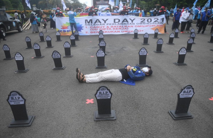 Another May Day: A group of workers mark Labor Day with a peaceful demonstration in Jakarta on May 1. They demanded the revocation of the Job Creation Law and the implementation of a minimum wage based on industrial sectors.