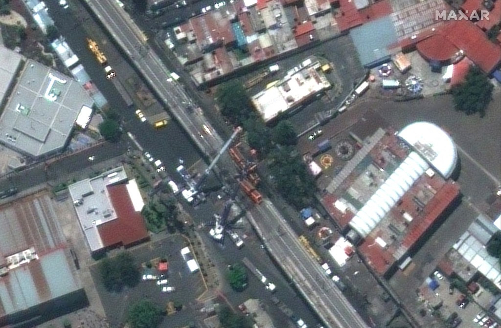 This handout satellite image released by Maxar Technologies shows a close-up overview of the collapse of an elevated metro train line in Mexico City, May 4, 2021. Mexico's president on Tuesday, May 4, promised an in-depth investigation to find those responsible for the deaths of at least 23 people in the collapse of an elevated metro train line with a history of problems.
