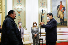 This handout picture released by the Venezuelan Presidency press office shows Venezuelan President Nicolas Maduro (right) talking with US actor Steven Seagal during a meeting at the Miraflores presidential palace in Caracas, on May 4, 2021. 