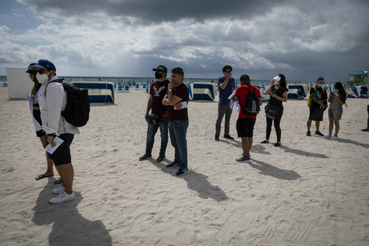 People wait in line to get Johnson & Johnson Covid-19 vaccine at a pop-up vaccination center at the beach, in South Beach, Florida, on May 9, 2021. 