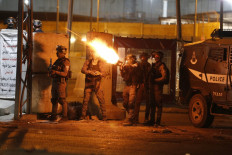 IDF soldiers fire tear gas at Palestinian demonstrators during an anti-Israel protest over tension in Jerusalem, at the Qalandiya checkpoint between Ramallah and Jerusalem, in the occupied West Bank, on May 11, 2021. 