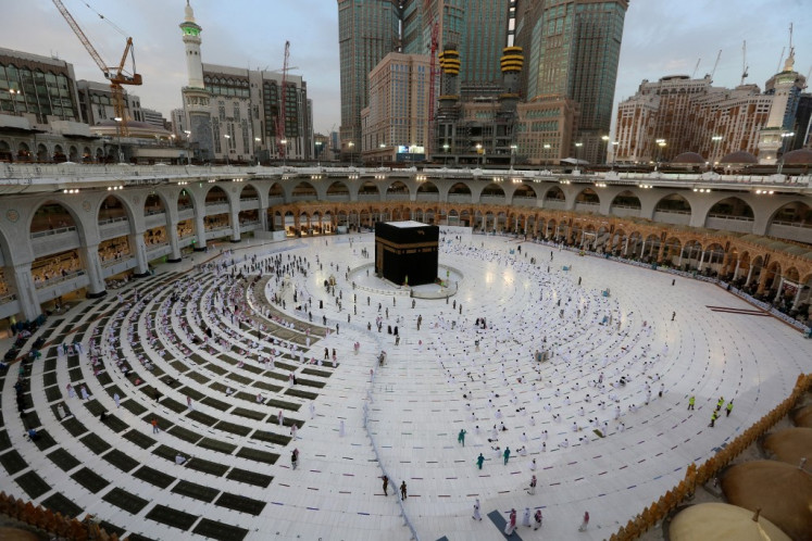 Muslim worshippers gather to pray round the Kaaba, the holiest shrine in the Grand Mosque complex in Saudi Arabia's holy city of Mecca, to mark the end of the fasting month of Ramadan, on May 13, 2021.
