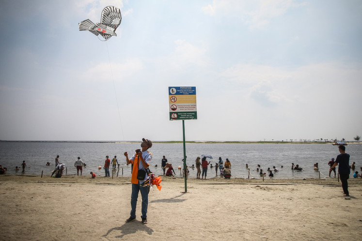 A hawker flies a kite at Carnaval Beach in Ancol Dreamland Park, North Jakarta, on Thursday. The city administration allowed people holding Jakarta identity cards to visit several tourist destinations across the capital during the Idul Fitri holiday.
