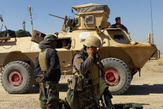Afghan security forces stand near an armored vehicle amid clashes with Taliban fighters in the Busharan area on the outskirts of Lashkar Gah, the capital of Helmand province, on May 5.
