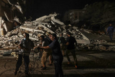 Palestinian firefighters search urgently for survivors and bodies under the rubble after an intensive civilian bombardment of Gaza City, 16 May 2021. Israel pummelled the Gaza Strip with air strikes, killing 10 members of an extended family and demolishing a building housing international media outlets, as Palestinian militants fired back barrages of rockets.
