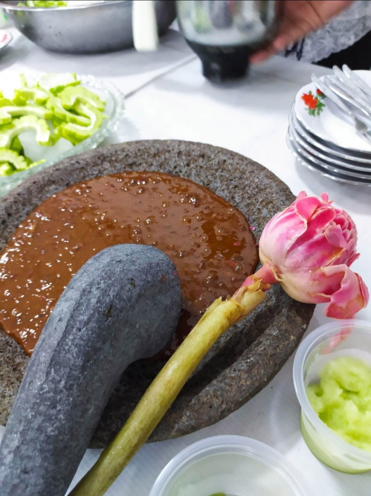 Bitter pill: A granite mortar containing 'sambal kecombrang' (chili sauce with torch flower) is served alongside 'rujak pare' (bitter melon salad) on May 13, 2021 at the Boen Hian Tong community hall in Semarang, Central Java. The dish represents the trauma and violence Chinese-Indonesian women experienced during the widespread riots on May 13-15, 1998. and is a tradition the community maintains every May 13.