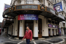 A pedestrian passes the Sondheim Theatre in central London, one of the many Britain's theatres reopening this week after a year of closure due to the pandemic.