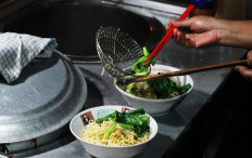 Delicious: A street vendor serves bowls of Wonogiri chicken noodle soup from his cart in Citayam, Bogor.