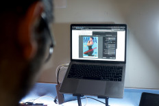 The cover of an old Indonesian LGBT+ magazine is seen on a screen while being digitised by Ais, a 29-year-old LGBT+ researcher, in Jakarta, Indonesia.