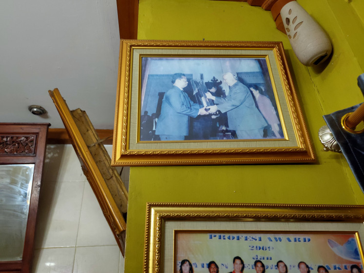 Memories: A framed photo kept by Tri showing her father Ratiman receiving the Upakarti Award from President Soeharto in 1990. 