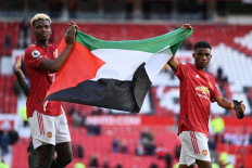 Manchester United's French midfielder Paul Pogba (left) and Manchester United's Ivorian midfielder Amad Diallo (right) walk around the pitch at the end of the game during the English Premier League football match between Manchester United and Fulham at Old Trafford in Manchester, north west England, on May 18, 2021.