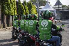 Gojek riders wait for their delivery orders at a distribution centre in Surabaya on May 17, 2021, as Gojek and Tokopedia unveiled a merger to form GoTo Group, creating the largest tech firm in the world's fourth most populous country.
