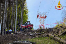 A photo taken and handout on May 23, 2021 by The Italian Firefighters "Vigili del Fuoco" shows rescuers working by a cable car that crashed to the ground in the resort town of Stresa on the shores of Lake Maggiore in the Piedmont region. Nine people died and another two were seriously injured Sunday after a cable car crashed to the ground in northern Italy, emergency services said.