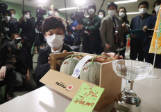 A man shows a pair of Yubari Melons which was sold for 2.7 million yen (about 25,000 USD) during the season's first auction at Sapporo Central Wholesale Market in Sapporo City, Hokkaido Prefecture on May 24, 2021.