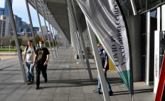 People walk past a Covid-19 vaccination centre in Melbourne on May 24, 2021 as the city records four new locally acquired cases of Covid-19 in the community after 85 day free of the virus. 