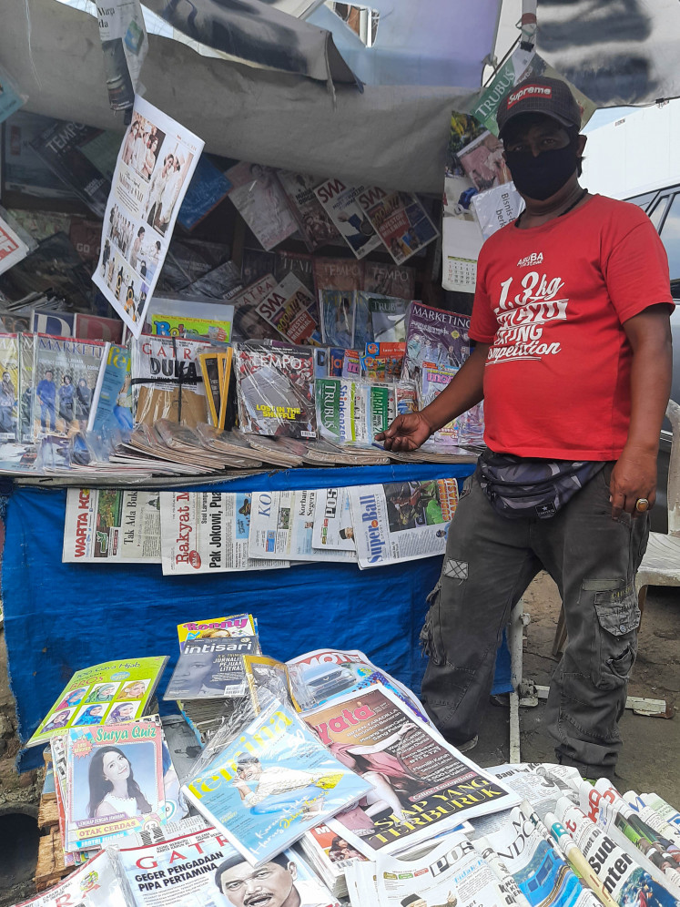 No longer thriving: Iwan stands in front of his newspaper stall.