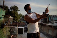 Pigeon fancier Pedro Marrero shows a pigeon in his rooftop in Havana, Cuba.