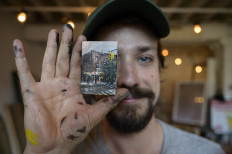 Tiny art: Artist Steve Wasterval poses for a photo with a mini painting at his studio in the Greenpoint district of the New York borough of Brooklyn.